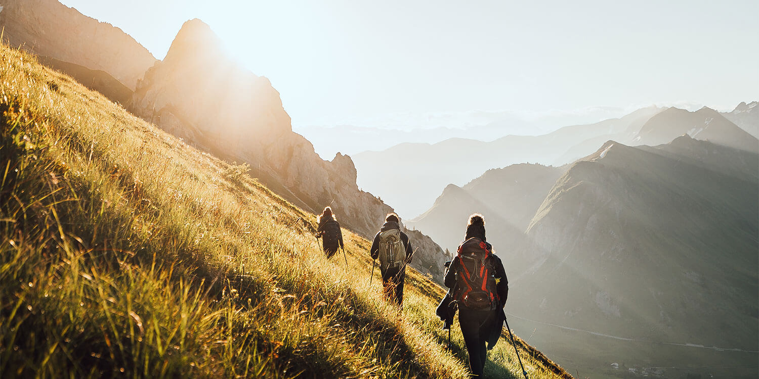 Photo de 3 personnes randonnant à travers la montagne