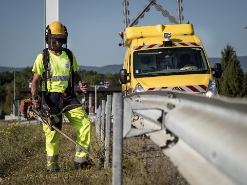 homme en jaune en train de faucher